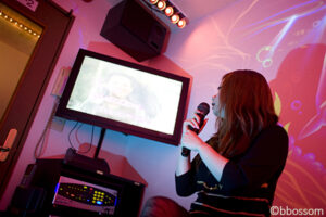 A young Japanese girl sings in a Karaoke box, in Shibuya, Tokyo, Japan